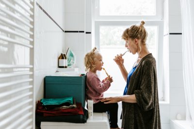 Mom with her child brushing teeth
