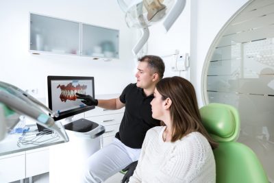 Dentist talks to patient about tooth erosion and enamel
