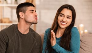 Woman avoiding a kiss because of bad breath